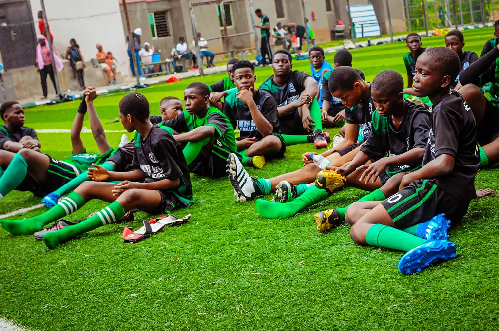 Players sitting together on the grass stretching after a session