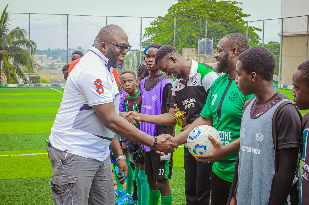 A guest presenting a football to Madestone players at a ceremony